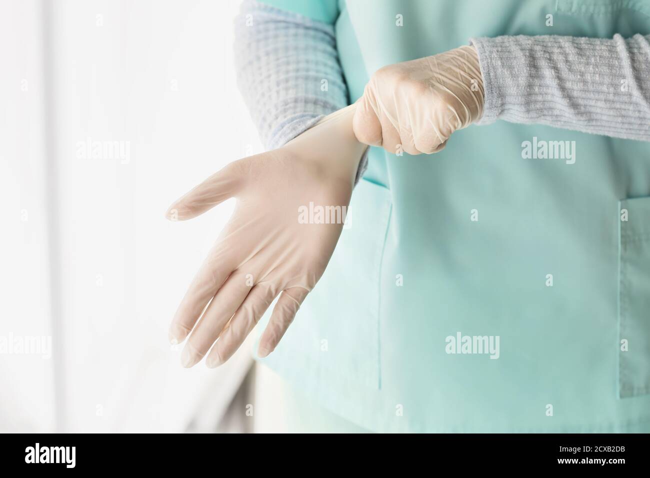 Putting on medical gloves hi-res stock photography and images - Alamy
