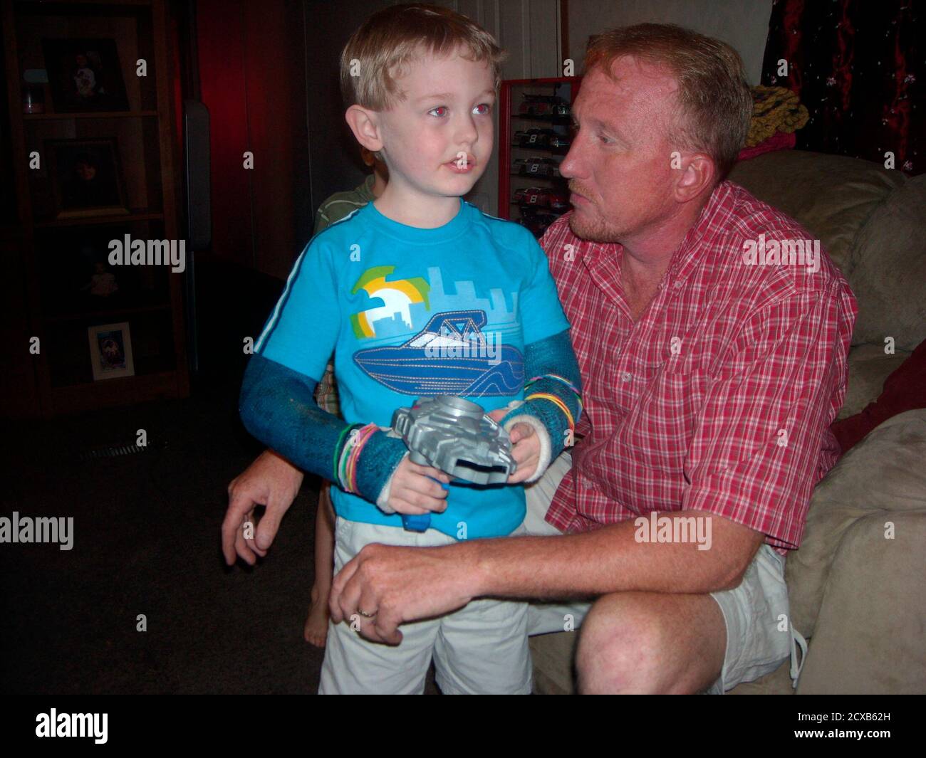 Five-year-old Garrett LeClere and his foster father Jeff McCormick are pictured in Phil Campbell, Alabama, May 24, 2011. Garrett is a son of McCormick's ex-wife who he had taken in after both of Garrett's parents were killed in the tornadoes. Many children lost loved ones in the killer tornadoes that carved up 610 miles of Alabama last month and left 238 dead. Though there is no official state count, a Reuters review of storms victims' obituaries found that at least eight young people were completely orphaned. Picture taken on May 24, 2011.  REUTERS/Verna Gates    (UNITED STATES - Tags: DISAST Stock Photo