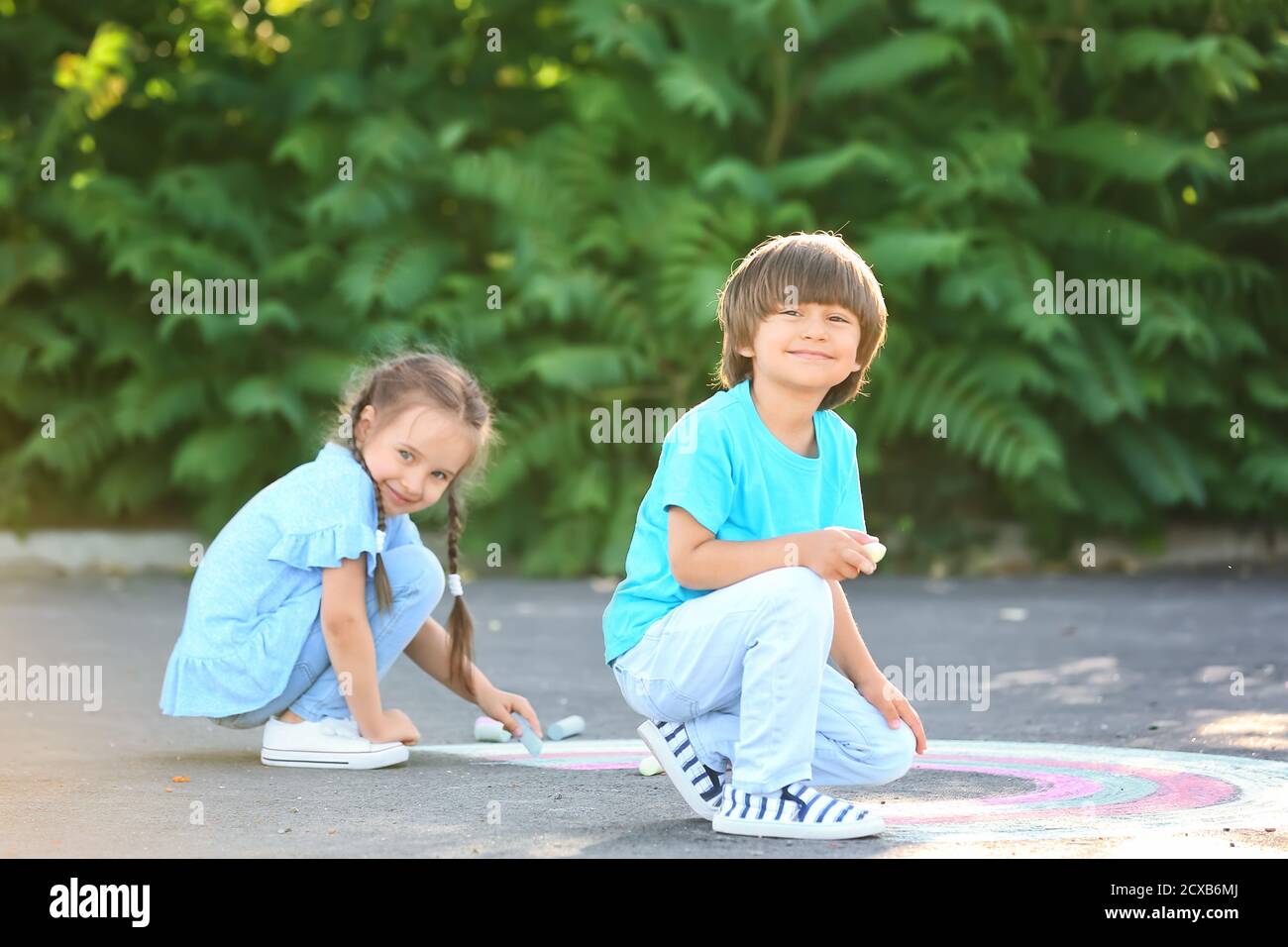 Little children drawing with chalk on asphalt Stock Photo - Alamy