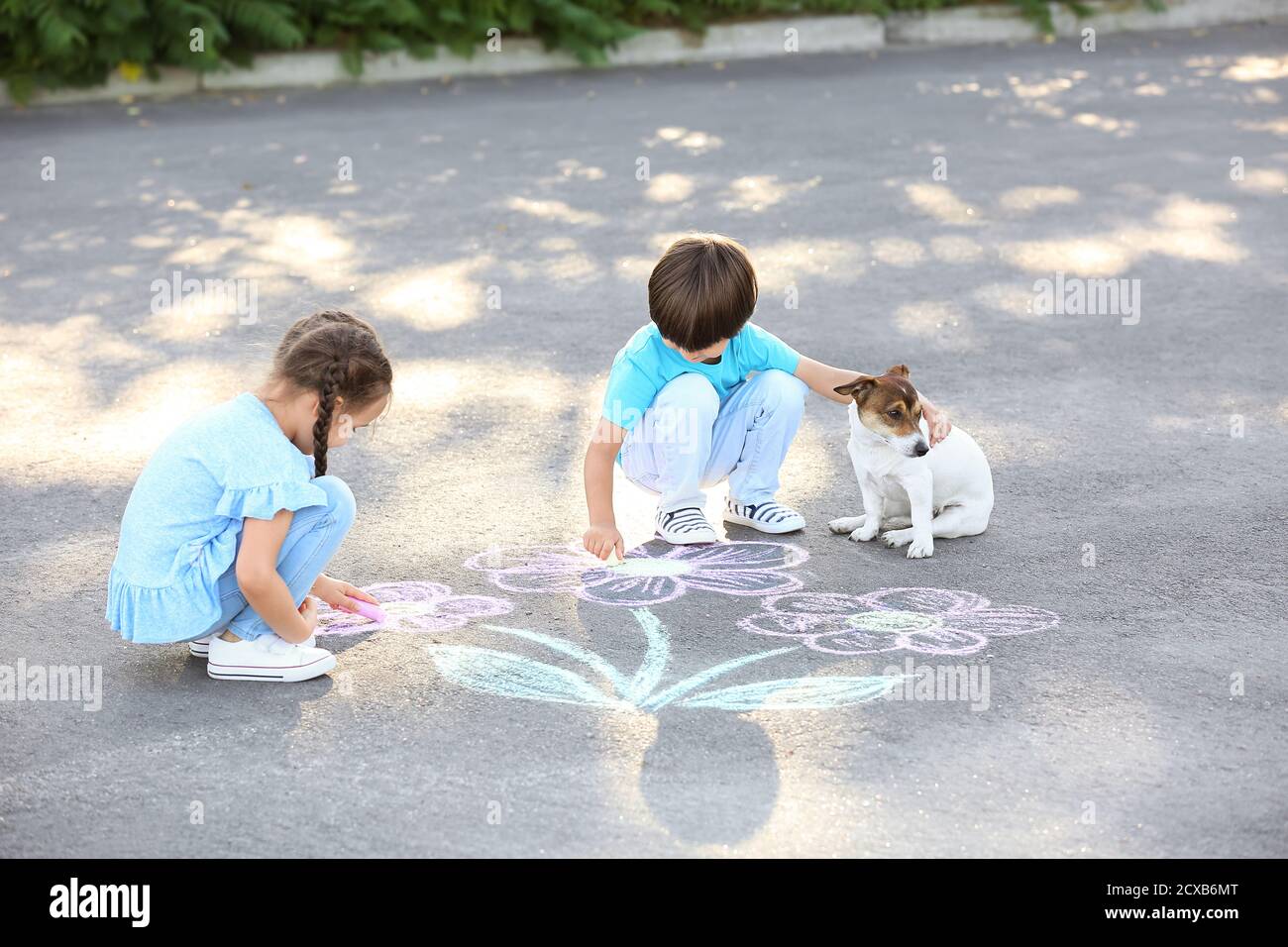 Little children drawing with chalk on asphalt Stock Photo - Alamy