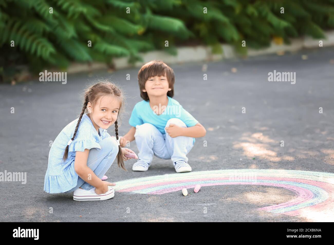 Little children drawing with chalk on asphalt Stock Photo - Alamy