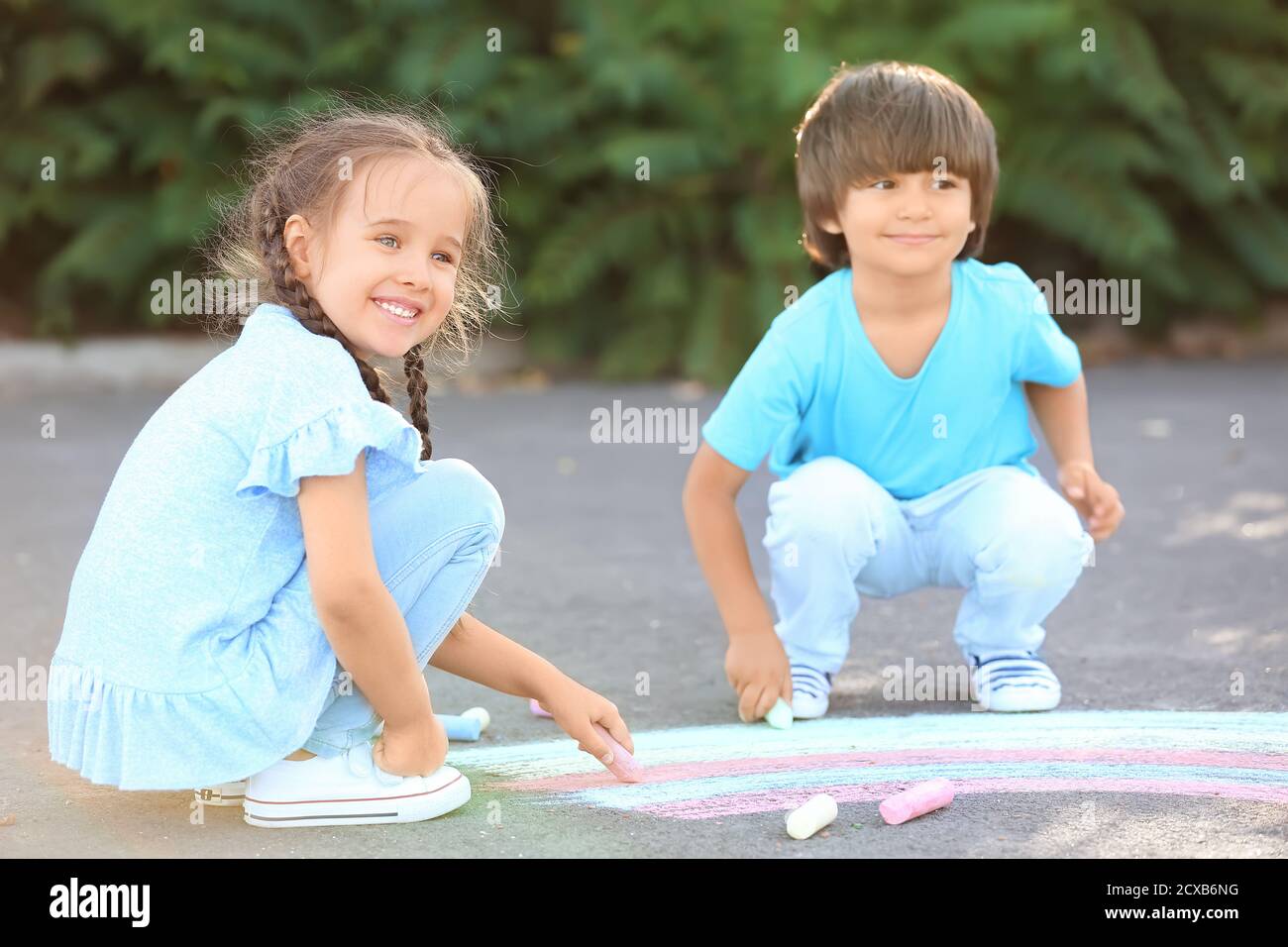 Little children drawing with chalk on asphalt Stock Photo - Alamy