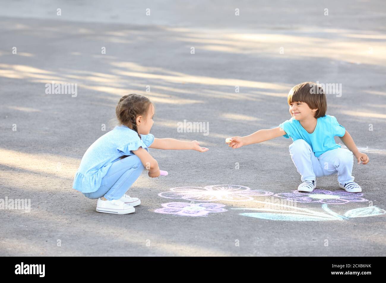 Little children drawing with chalk on asphalt Stock Photo - Alamy