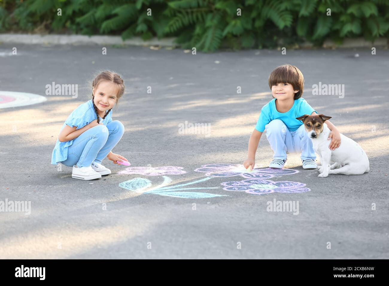 Little children drawing with chalk on asphalt Stock Photo - Alamy