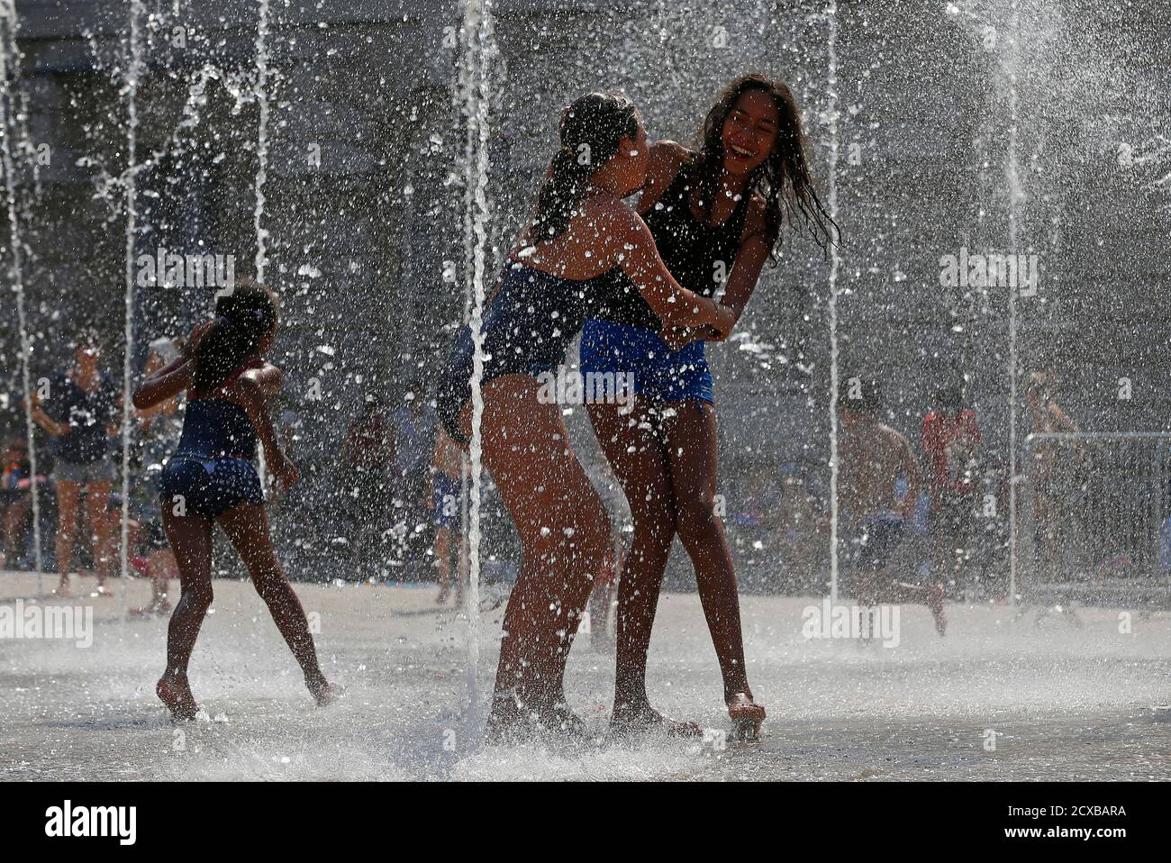 Young girls enjoy the hot weather playing in fountains in central London ahead of the London 2012 Olympic Games July 25, 2012.     REUTERS/Eddie Keogh (BRITAIN - Tags: ENVIRONMENT SPORT OLYMPICS CITYSPACE) Stock Photo