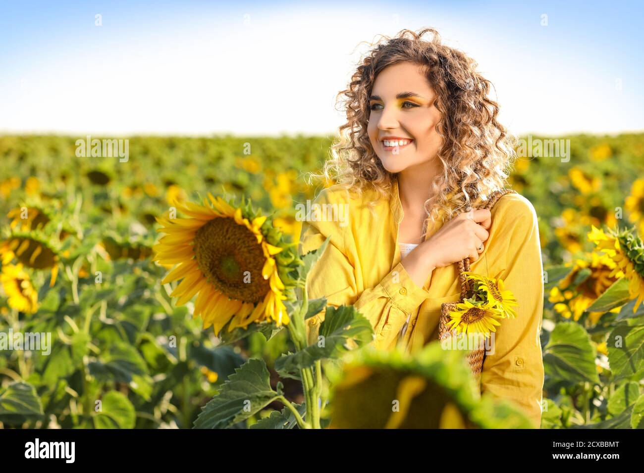 Beautiful young woman in sunflower field Stock Photo - Alamy