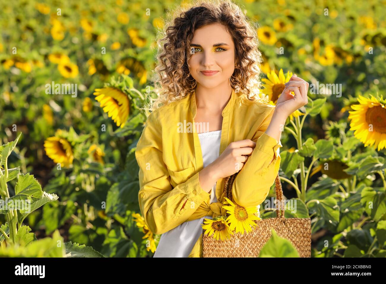 Beautiful young woman in sunflower field Stock Photo - Alamy