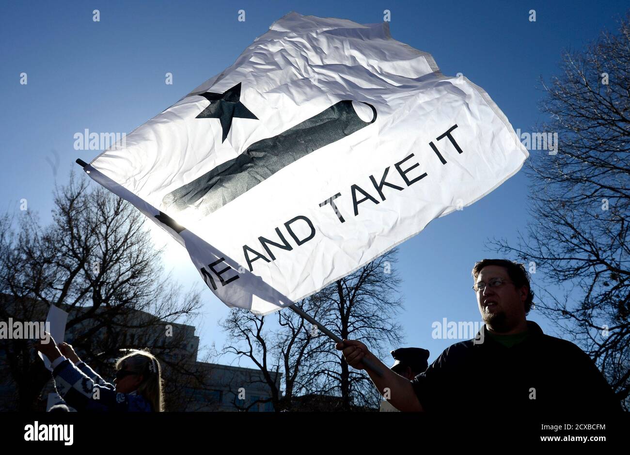 Josh Westerlund of Colorado Springs, holds a flag with a cannon pictured and the words 'Come and Take it' written on it at the Colorado State Capital Building during an anti-gun control legislation rally organized by Guns for Everyone in Denver, Colorado January 9, 2013. Vice President Joe Biden said on Wednesday the White House plans to act quickly to curb gun violence and will explore all avenues - including executive orders that would not require the approval of Congress - to try to prevent incidents like last month's massacre at a Connecticut school. REUTERS/Mark Leffingwell  (UNITED STATE Stock Photo
