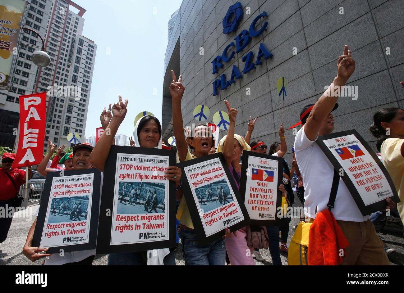 Filipino activists and overseas Filipino workers gesture as they chant slogans during a rally outside the premises of the Taipei Economic and Cultural Office (TECO) in Manila's Makati financial district May 22, 2013. Dozens of rallyists called on the Taiwanese government to ensure the safety and job security of tens of thousands of Filipinos working in Taiwan, according to a statement from a Filipino labor group. They also appealed to the Taiwanese people to refrain from using violence against Filipino workers who have nothing to do with the current political row between the two countries over Stock Photo