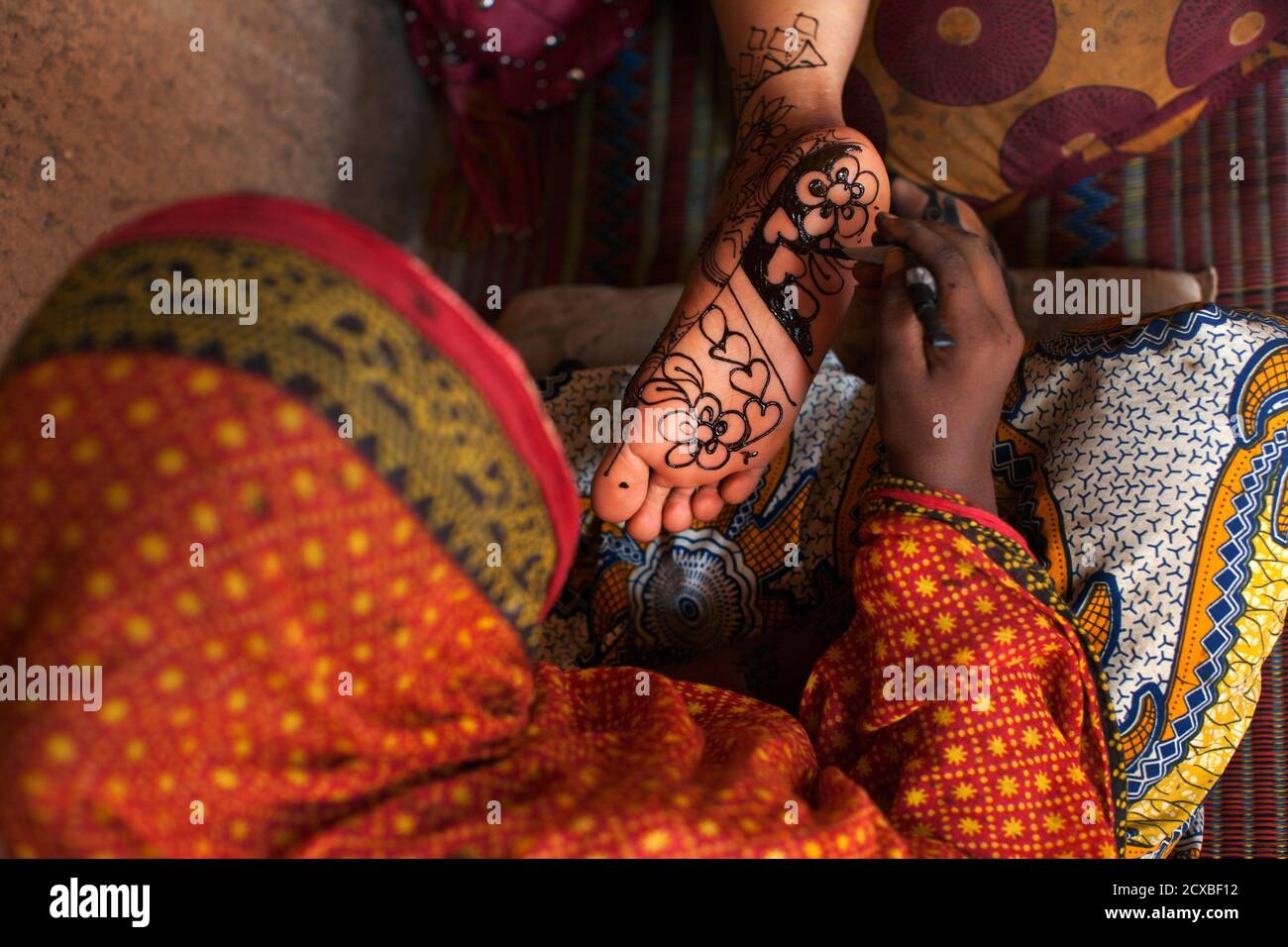 Henna tattoo artist Salimatou Lamidou applies ink on a customer at her house and studio in Niamey, September 20, 2013. In Niger, women pay up to $30 for henna tattoos on their Henna tattoo artist Salimatou Lamidou applies ink on a customer at her house and studio in Niamey, September 20, 2013. In Niger, women pay up to $30 for henna tattoos on their