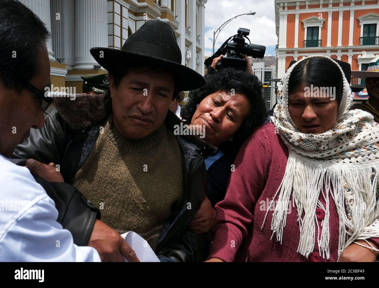 Indigenous leader Rafael Quispe (2nd L), a former leader of Bolivia's CONAMAQ (National Council of Ayllus and Markas of Qullasuyu), and his wife Rocio (R) leave the congress building, after ending their hunger strike protest in La Paz, October 7, 2013. The CONAMAQ, a confederation to politically represent certain indigenous communities, were protesting against the results of the last census, which caused the geographical region they represent to lose congressional seats for the next legislative elections in 2014, according to local media. The hunger strikers called off their protest on Monday, Stock Photo