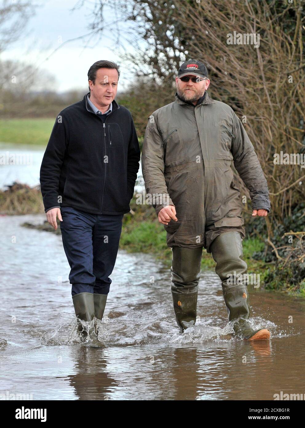 Britain's Prime Minister David Cameron chats with farmer Tony Davy (R) during a visit to flood affected area at Goodings Farm in Fordgate, Somerset February 7, 2014. REUTERS/Tim Ireland/Pool (BRITAIN - Tags: DISASTER POLITICS ENVIRONMENT) Stock Photo