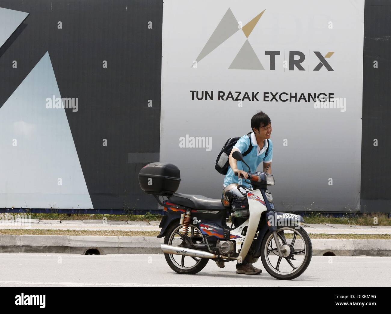 A man pushes his bike past 1 Malaysia Development Berhad (1MDB) flagship  Tun Razak Exchange development in Kuala Lumpur, Malaysia, July 3, 2015.  Malaysian Prime Minister Najib Razak slammed a report that