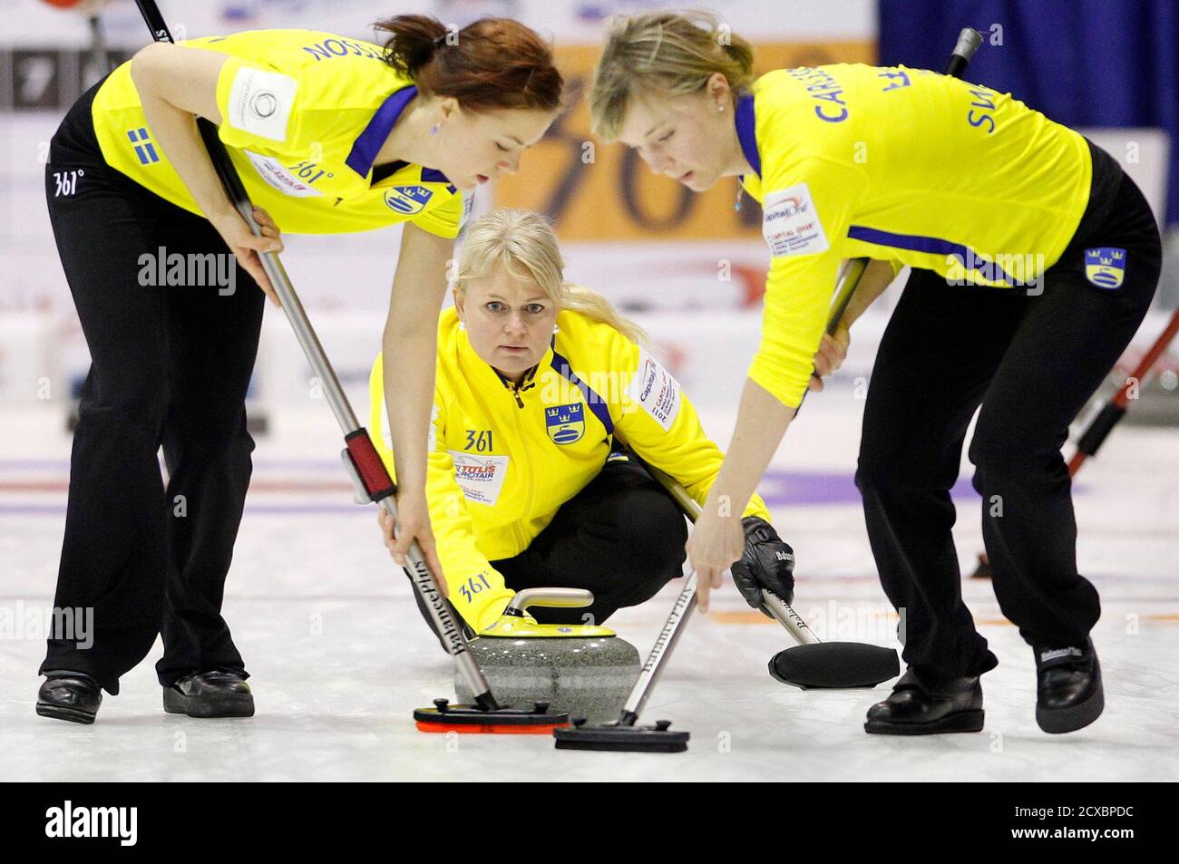 Sweden's skip Anette Norberg (C) watches the line of her shot as lead Lotta  Lennartsson (L) and second Sara Carlsson play during their match against  the Czech Republic at the World Women's