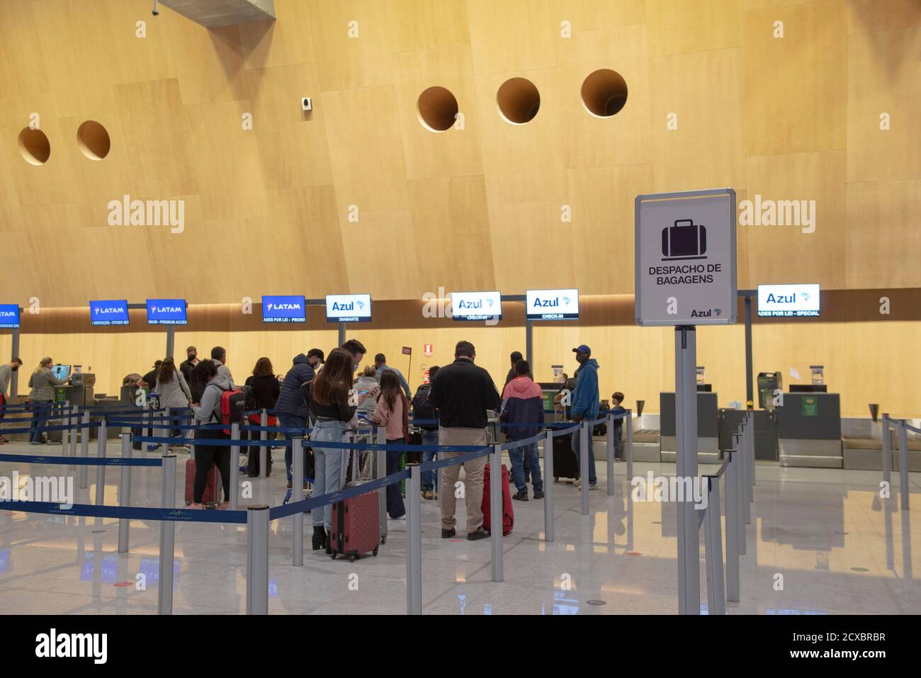 Florianopolis, Brazil. September 19, 2020: Queue to check baggage at the airport. People crowded during the pandemic. Written sign Checked baggage (De Stock Photo