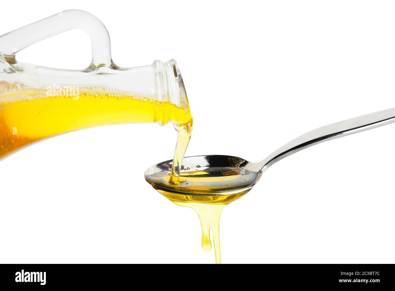Pouring of fresh olive oil from bottle into spoon on white background ...
