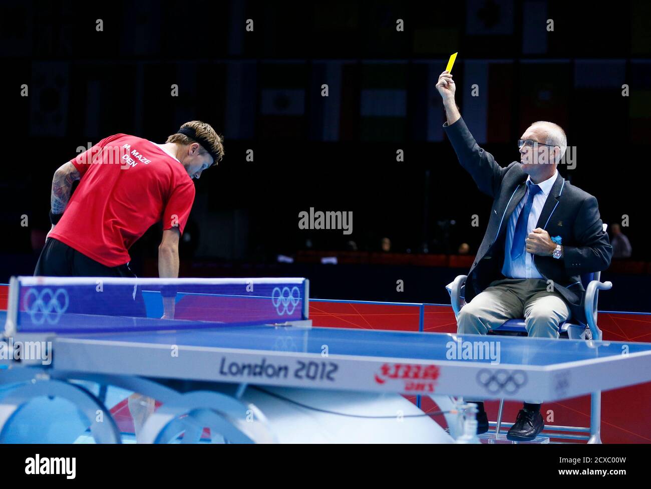 Denmark's Michael Maze gets a yellow card from the umpire for throwing the  ball in his men's singles quarterfinals table tennis match at the ExCel  venue against Germany's Dimitrij Ovtcharov during the