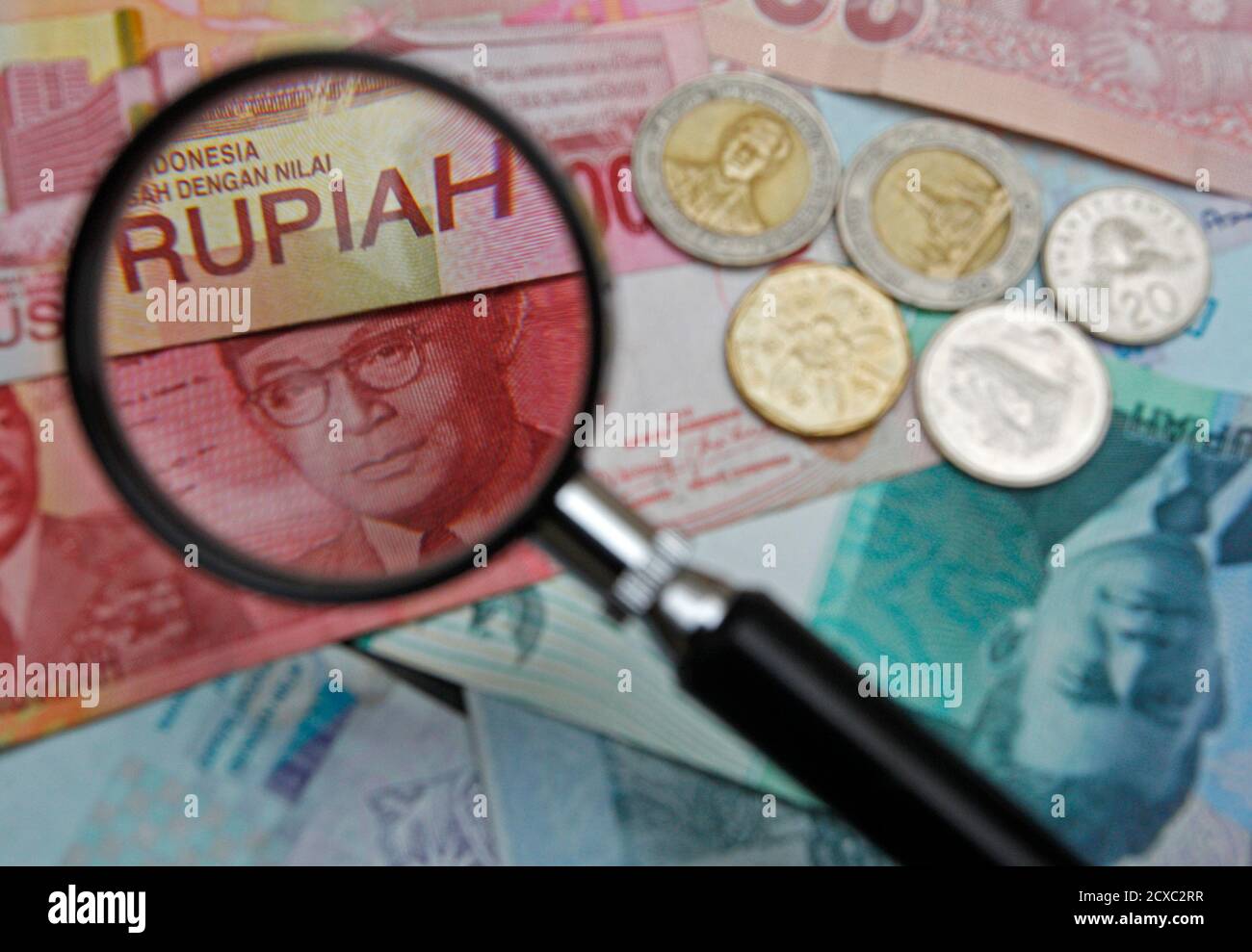 a 100000 indonesian rupiah note is seen through a magnifying glass among other southeast asian currencies in this photo illustration taken in singapore march 14 2013 picture taken march 14 2013 to match insight singapore ndf reutersedgar su singapore tags business 2CXC2RR