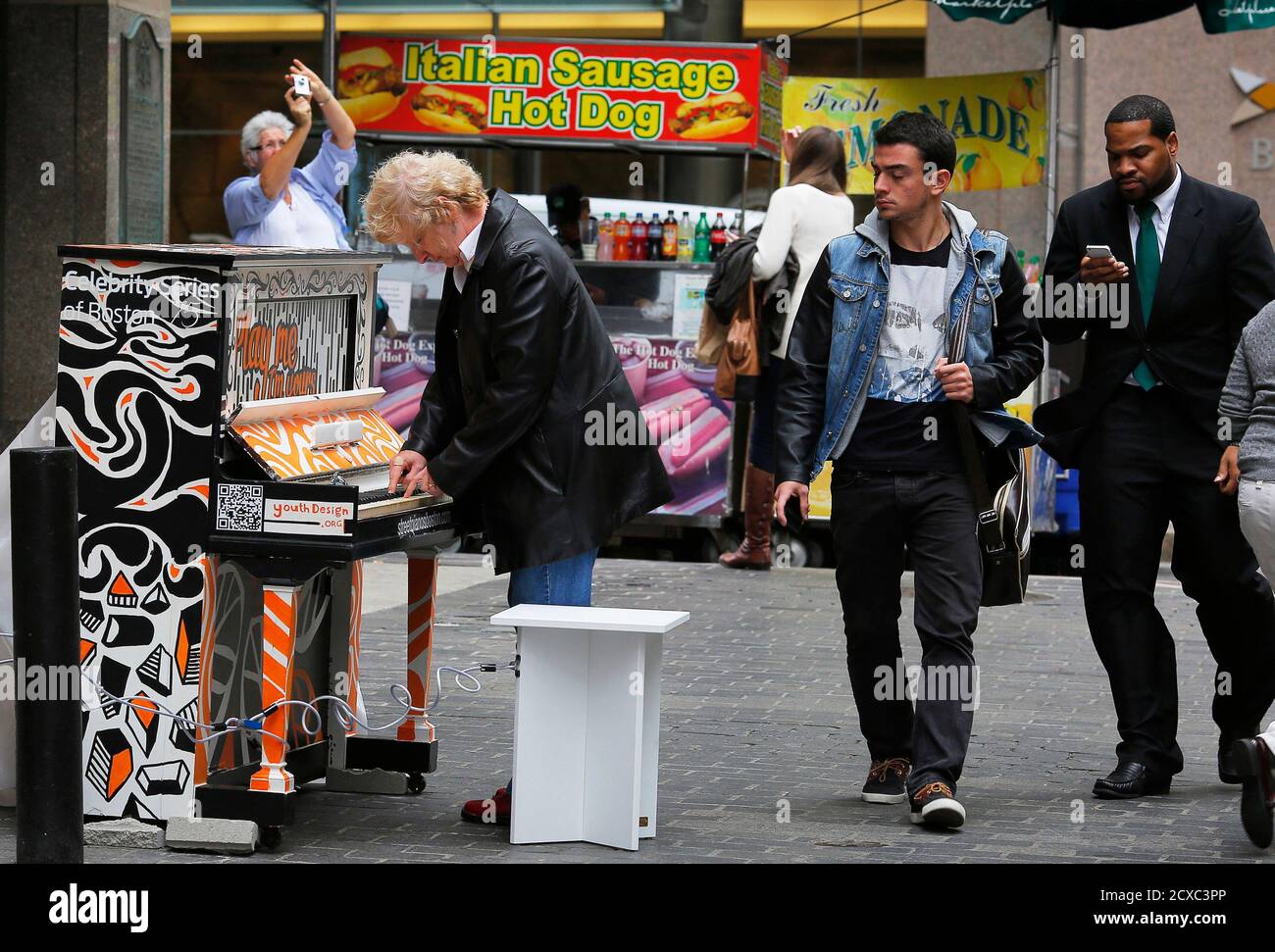 A passerby plays a few notes on a piano near the Old State House in  downtown Boston, Massachusetts September 27, 2013. Celebrity Series of  Boston is presenting "Play Me, I'm Yours: the