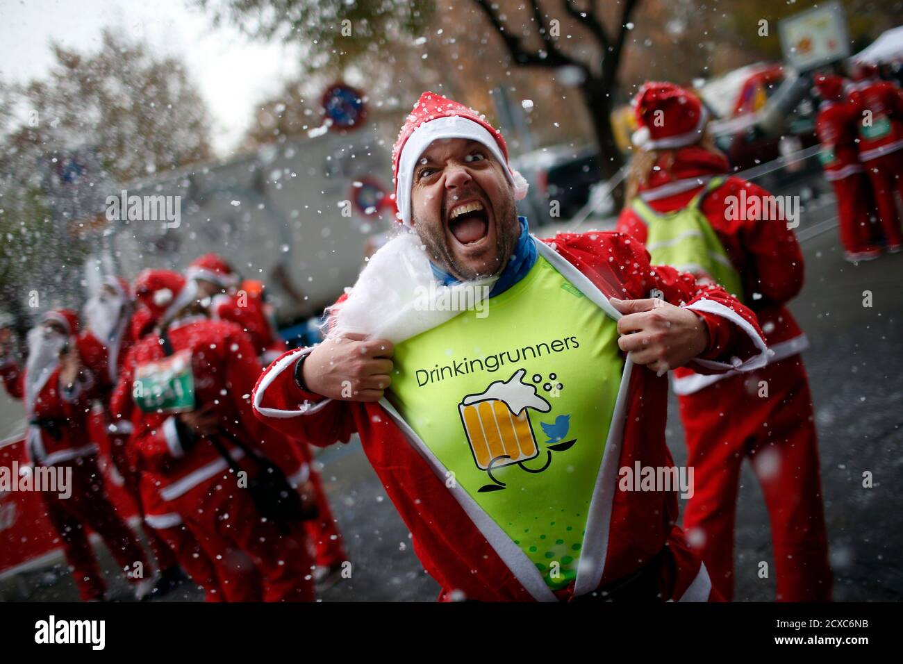 A man dressed in a Santa outfit reacts for the camera under artificial snow  at the end of the annual Carrera de Papa Noel (Santa Claus Run), in Madrid,  December 13, 2014.