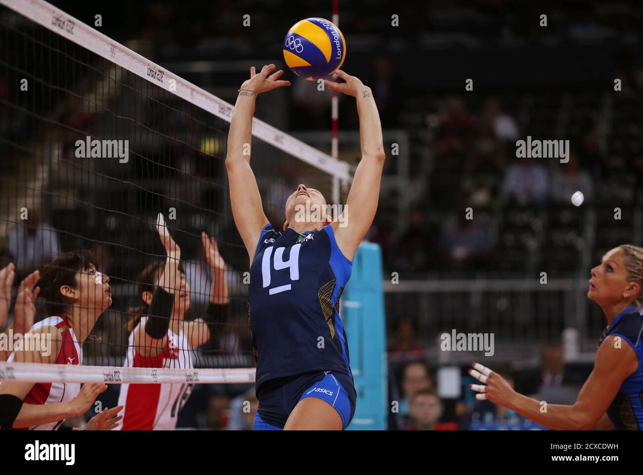 Italy's captain Eleonora Lo Bianco (2nd R) sets up the ball for teammate  Simona Gioli as Japan's Ai Otomo and Yukiko Ebata (2nd L) defend during  their women's Group A volleyball match