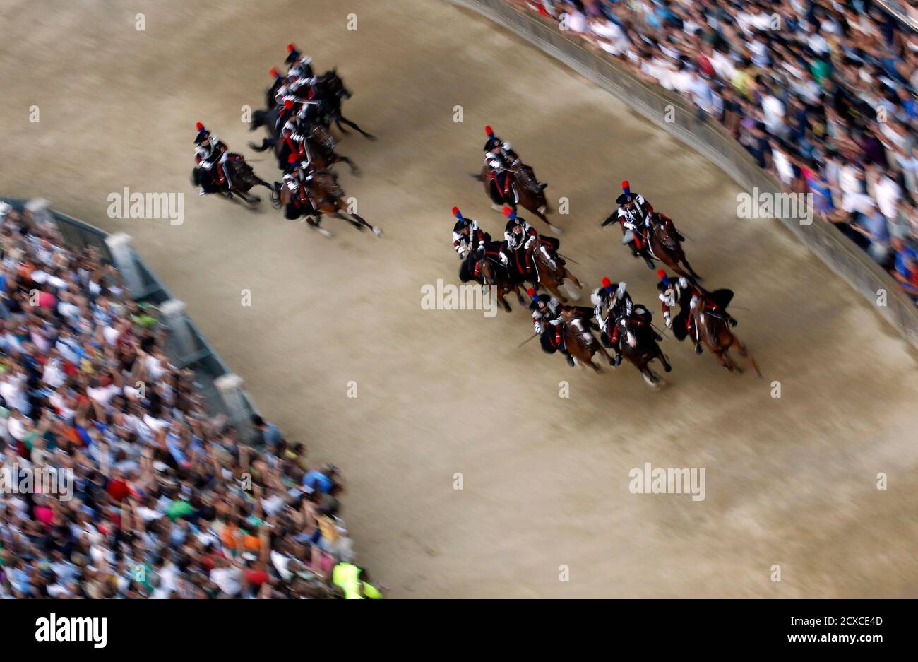 Mounted Italian Carabinieri police charge around the track with swords drawn prior to a training session of the Palio race in Siena's main square August 15, 2012. Every year on August 16, almost without fail since the mid-1600s, 10 riders compete bareback around Siena's shell-shaped central square in a bid to win the Palio, a silk banner depicting the Madonna and child. REUTERS/Alessandro Bianchi (ITALY - Tags: SOCIETY ANIMALS SPORT HORSE RACING) Stock Photo