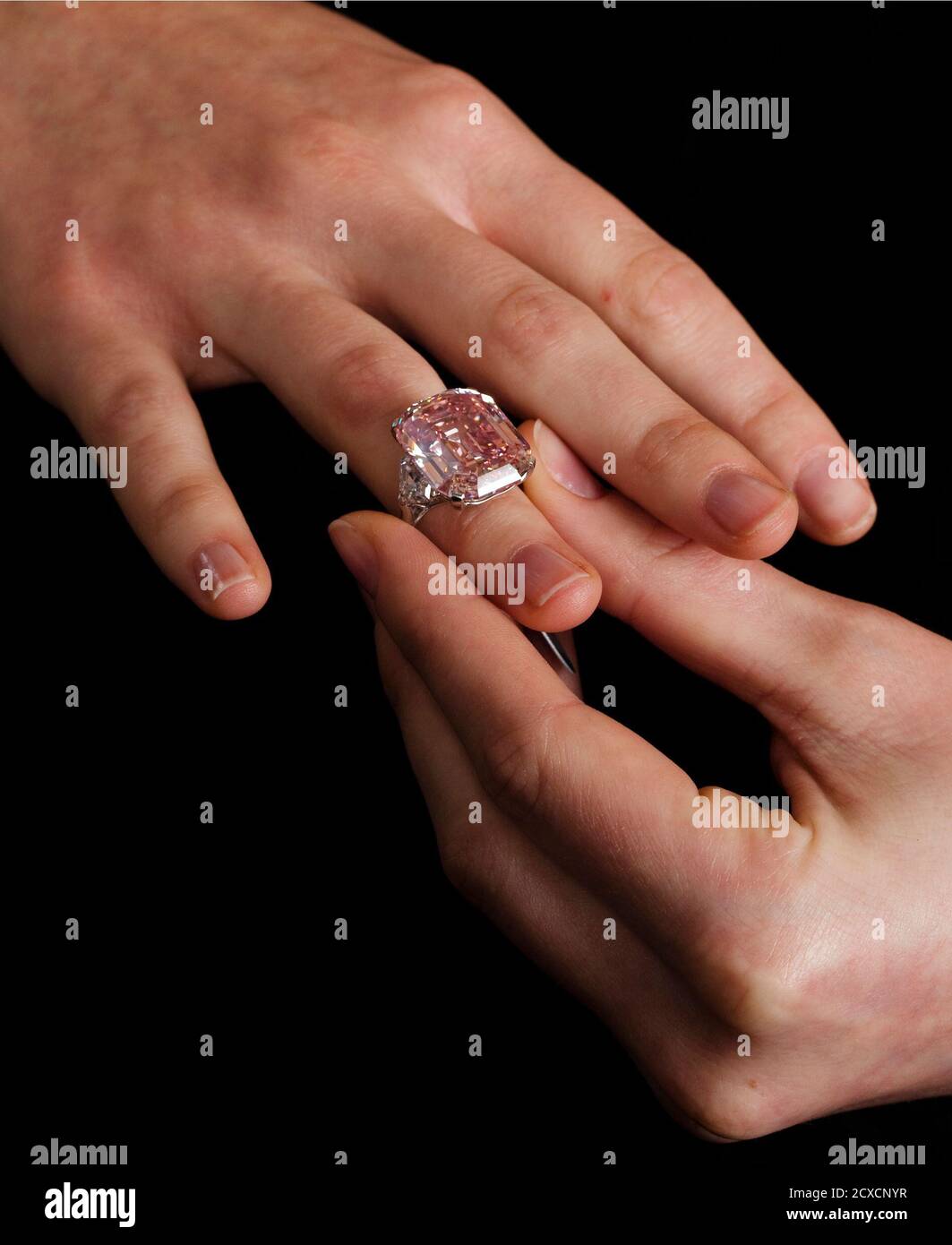 An employee poses with a 24.78 carat Fancy Intense Pink diamond at  Sotheby's in Geneva November 10, 2010. The diamond, mounted as a ring, is  estimated to fetch up to $38 million