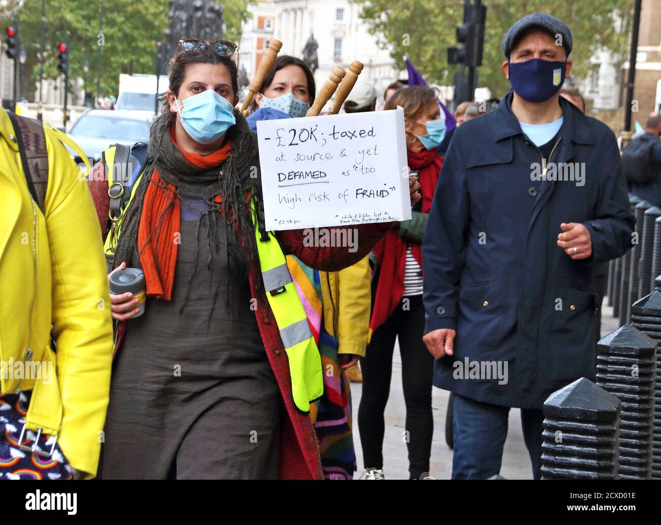London, UK. 30th Sep, 2020. Protester wearing a face mask holding a placard  during the march.Pantomime Dames and various creatives and freelancers  march to Parliament in Westminster in call for action to