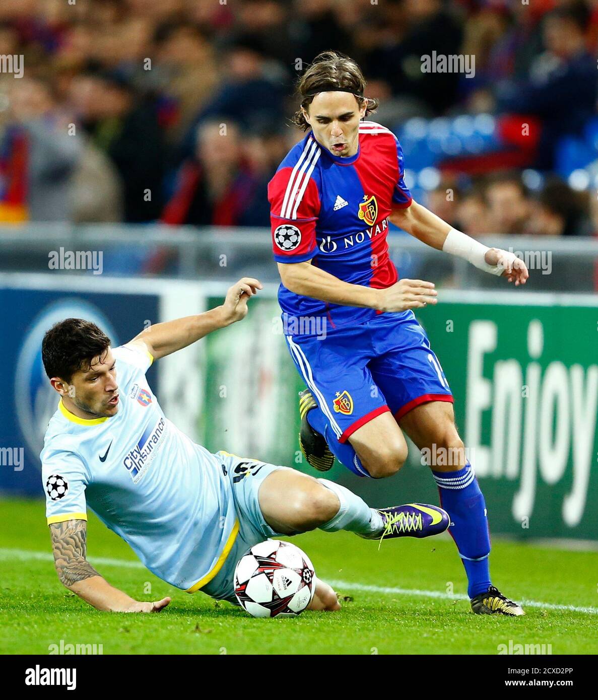 FC Basel's Kay Voser challenges Steaua Bucharest's Cristian Tanase (L)  during their Champions League Group E soccer match at St. Jakob-Park in  Basel November 6, 2013. REUTERS/Ruben Sprich (SWITZERLAND - Tags: SPORT