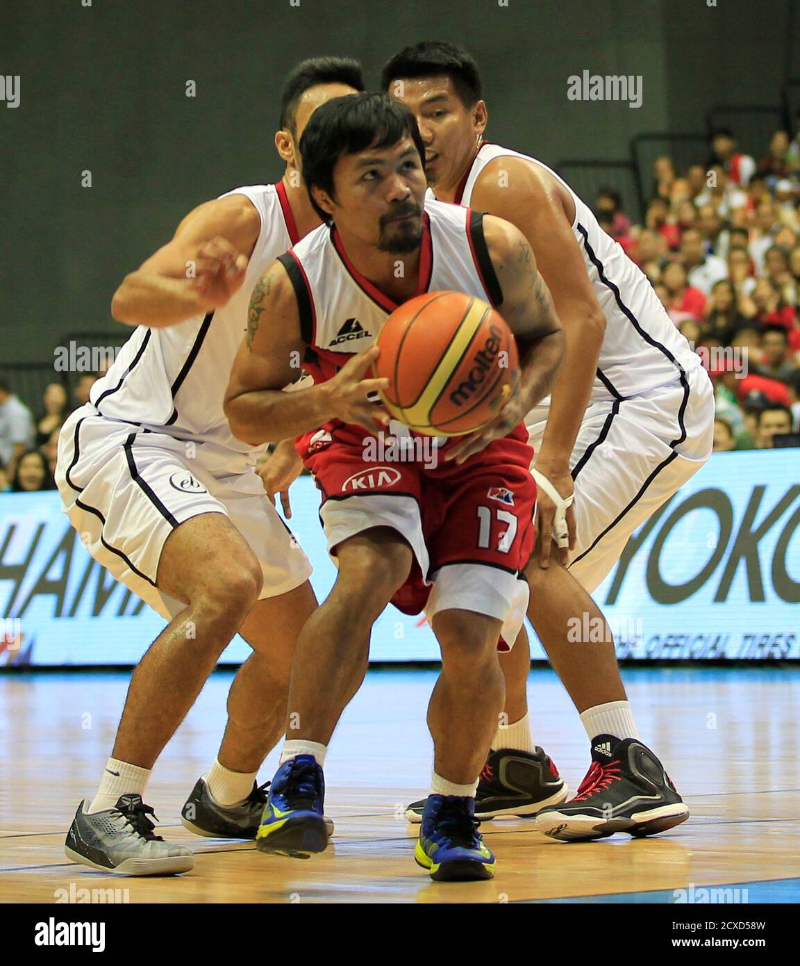 Manny Pacquiao, a playing coach of KIA-Sorento, is guarded by players of  Blackwater-Elite during the first quarter of the 40th Season of the Philippine  Basketball Association (PBA) games in Bocaue town, Bulacan