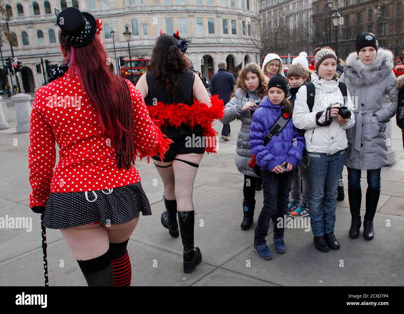 Tourists watch as burlesque enthusiasts and staff of a holiday travel firm walk through Trafalgar Square after a media stunt outside the National Gallery in London January 3, 2011. The stunt was organised by Virgin Holidays in an attempt to break the world record for the world's largest burlesque dance.  REUTERS/Suzanne Plunkett (BRITAIN - Tags: SOCIETY TRAVEL) Stock Photo