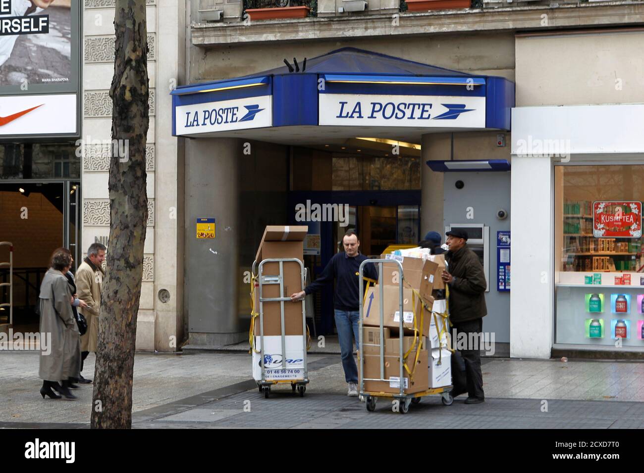 French postal service workers bring out postal packets from the post office  of the Champs Elysees Avenue in Paris January 11, 2011. High rents on the  Champs Elysees force this post office