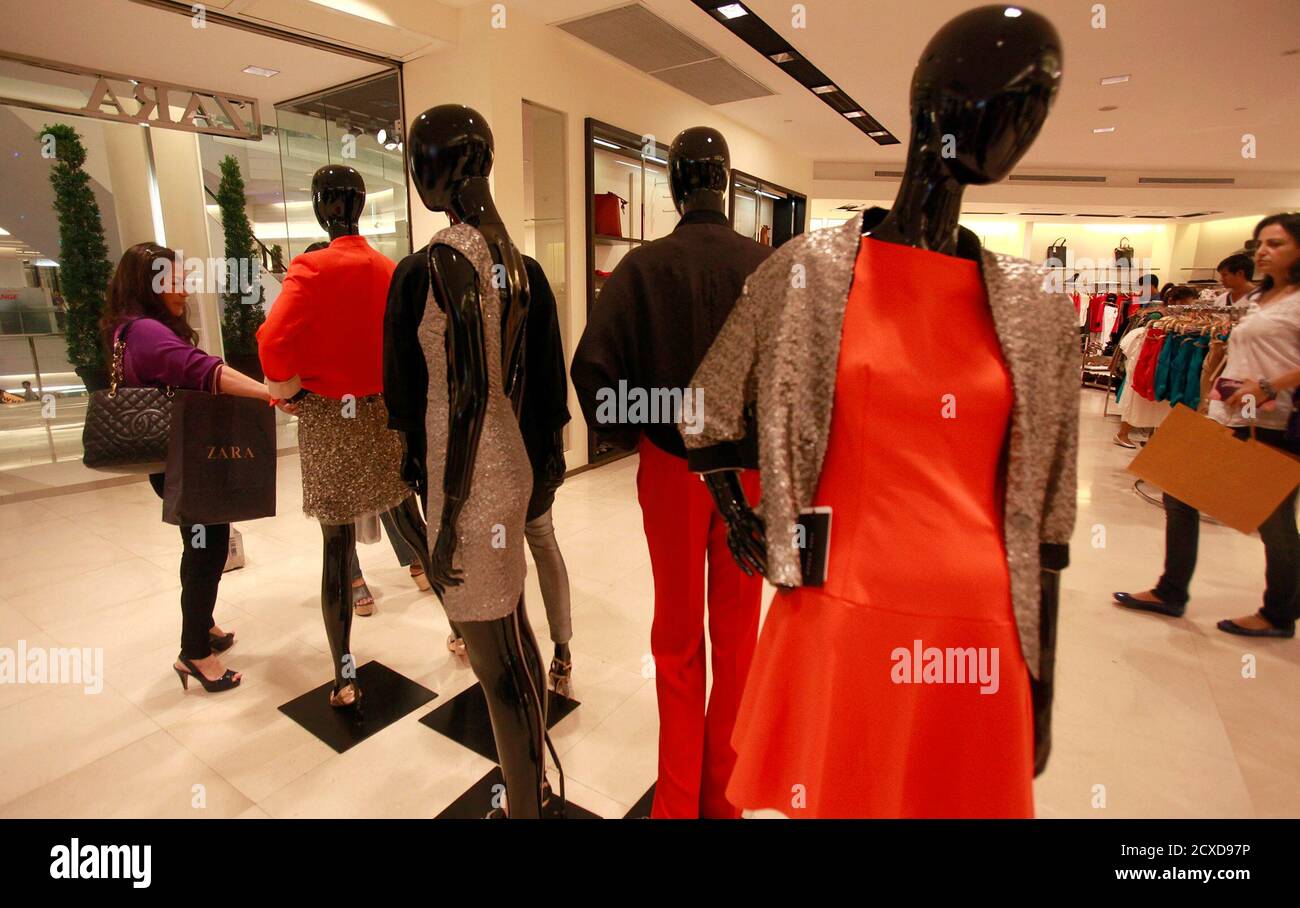 Women choose clothes at a Zara shop in Siam Paragon shopping mall in  Bangkok June 29, 2011. As pop music blares from a Zara store in Bangkok,  Suthip Nanthavong jostles with others