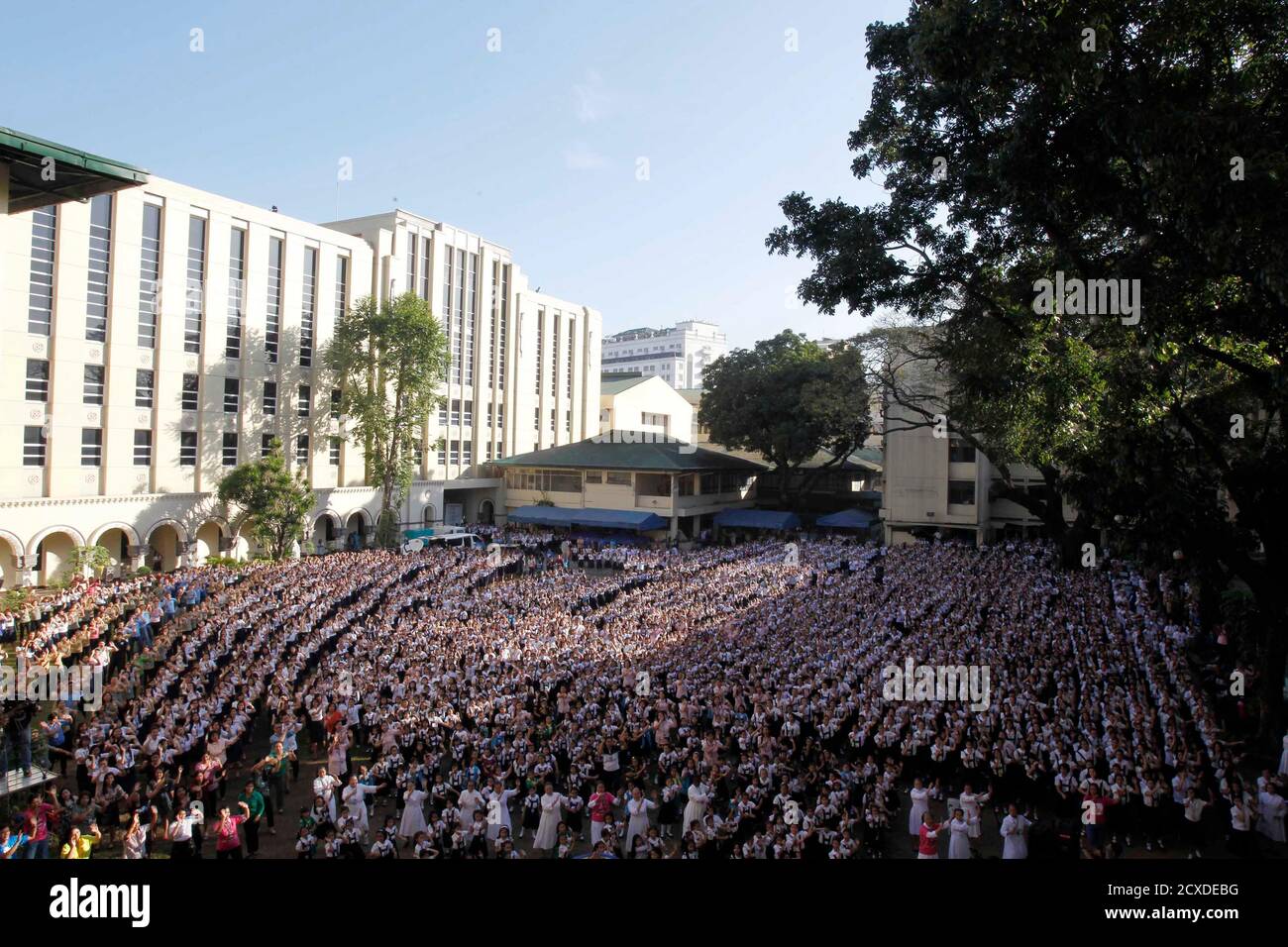Thousands of students and faculty members dance to the theme song of the One Billion Rising campaign in the quadrangle of the St. Scholastica college in Manila February 14, 2013. One Billion Rising is a global campaign to call for an end to violence against women and girls, according to its organisers.  REUTERS/Romeo Ranoco (PHILIPPINES - Tags: POLITICS SOCIETY EDUCATION) Stock Photo