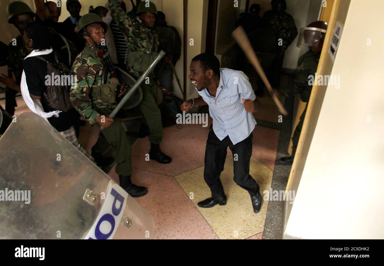 Riot policemen use batons to beat up a rioting University of Nairobi student in Kenya's capital Nairobi May 20, 2014. Public university students started their protests, which are against the planned hiking of fees and lowering of maximum loan awarded to students by the Higher Education Loans Board, where police engaged the students in running battles at the main campus, local media reported. REUTERS/Thomas Mukoya (KENYA - Tags: BUSINESS EDUCATION CIVIL UNREST TPX IMAGES OF THE DAY) Stock Photo
