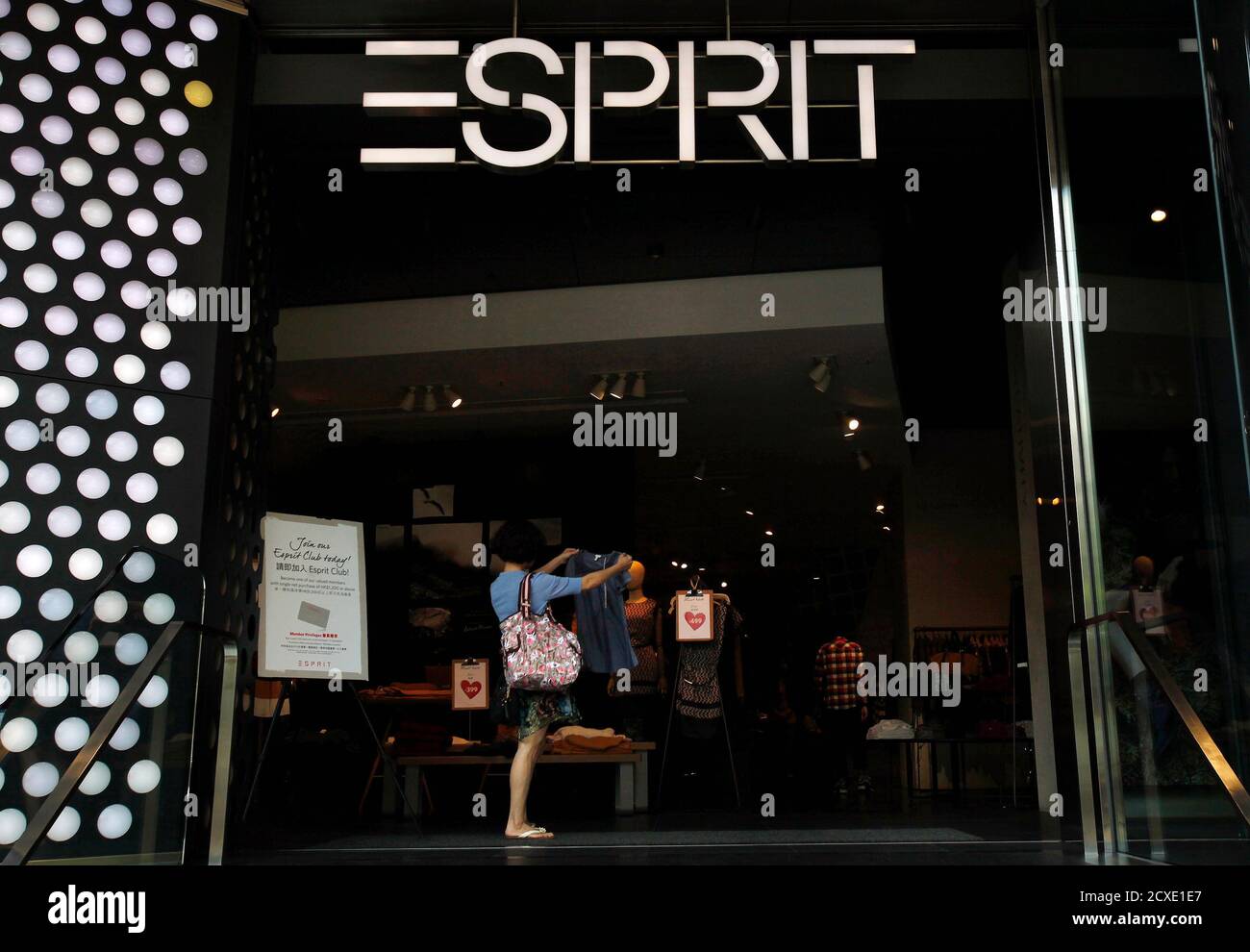 A customer checks a shirt inside the biggest Esprit store at Hong Kong's  Tsim Sha Tsui shopping district September 10, 2013. Europe-focused retailer  Esprit Holdings Ltd does not expect to post a