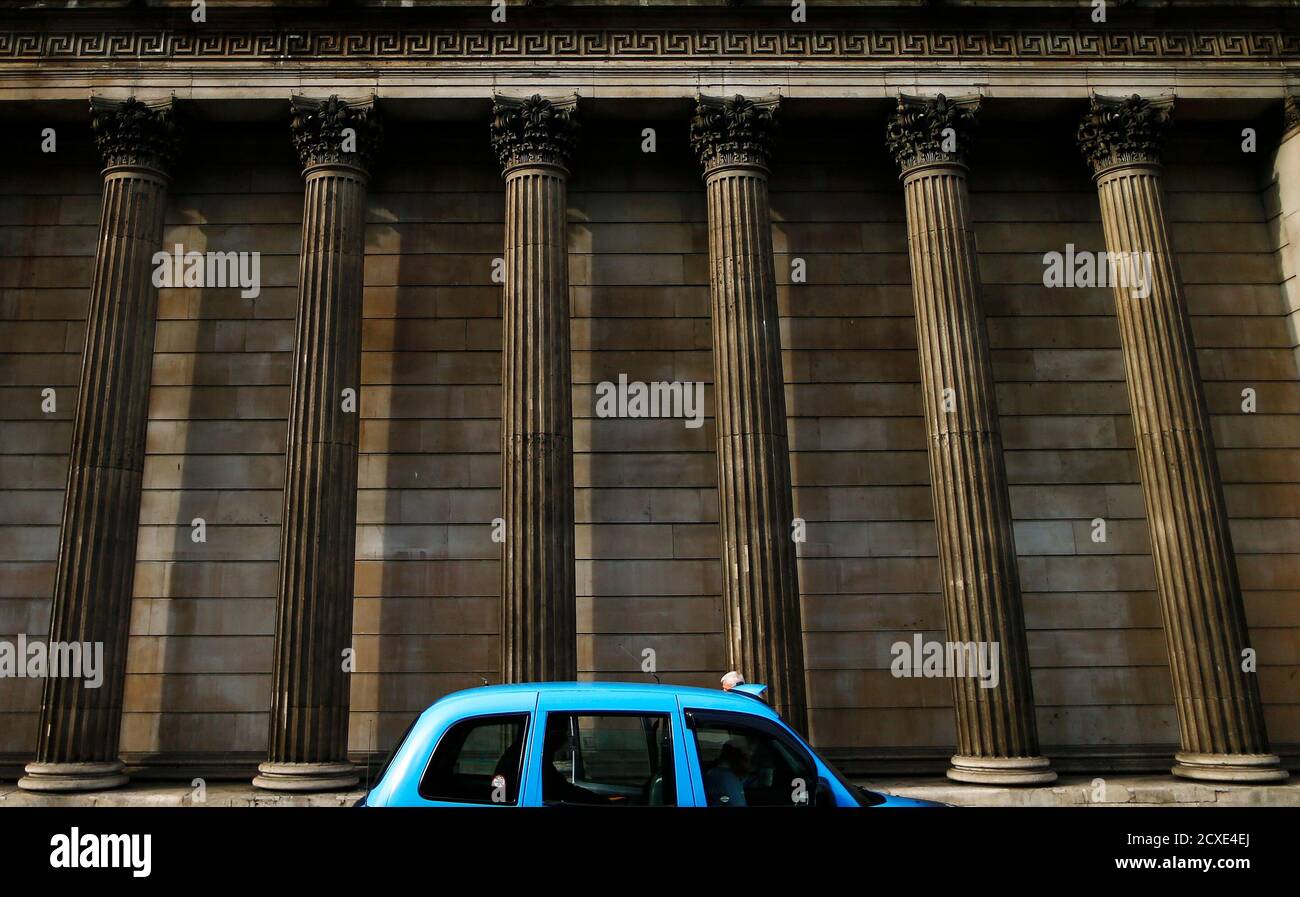 A taxi stops in front of the columns of the Bank of England in the city of London, October 17, 2014. Britain's economic recovery might stall if interest rates rise too soon, the Bank of England's chief economist said on Friday as he offered the strongest signal yet that the bank is prepared to delay increases in borrowing costs. REUTERS/Andrew Winning (BRITAIN - Tags: BUSINESS POLITICS) Stock Photo