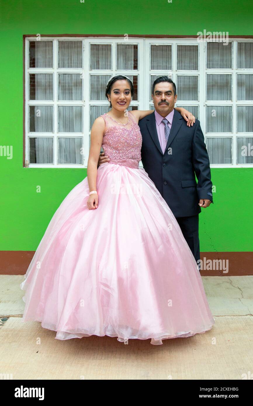 Young girl in her quinceanera dress standing with her father Stock Photo