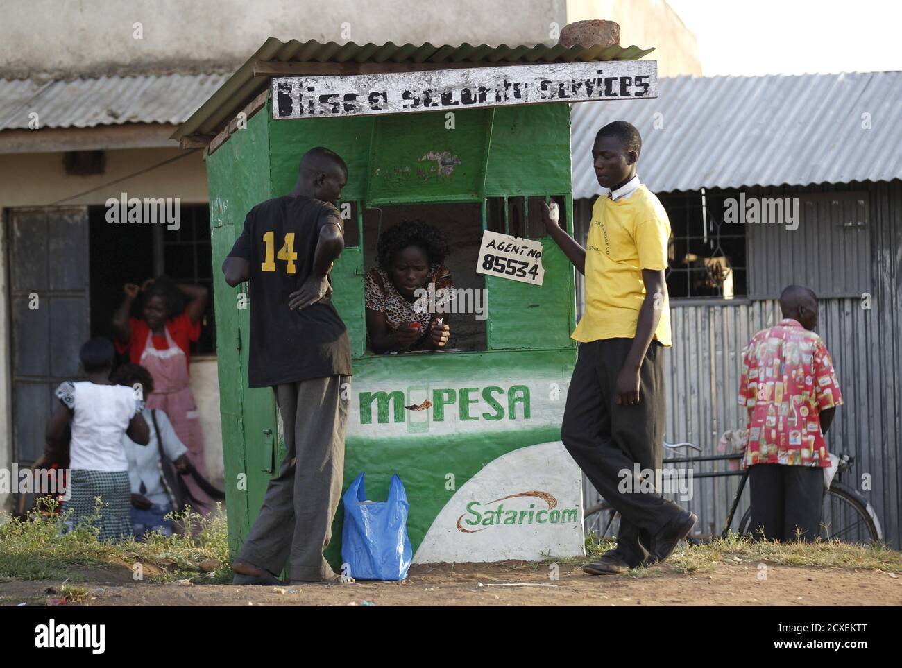 Residents perform at a mobile phone transaction at a stall within the trading centre of the U.S. President Barack Obama's ancestral village of Nyang'oma Kogelo, west of Kenya's capital Nairobi, July 15, 2015. President Obama visits Kenya and Ethiopia in July, his third major trip to Sub-Saharan Africa after travelling to Ghana in 2009 and to Tanzania, Senegal and South Africa in 2011. He has also visited Egypt, in North Africa, and South Africa for Nelson Mandela's funeral. Obama will be welcomed by a continent that had expected closer attention from a man they claim as their son, a sentiment  Stock Photo