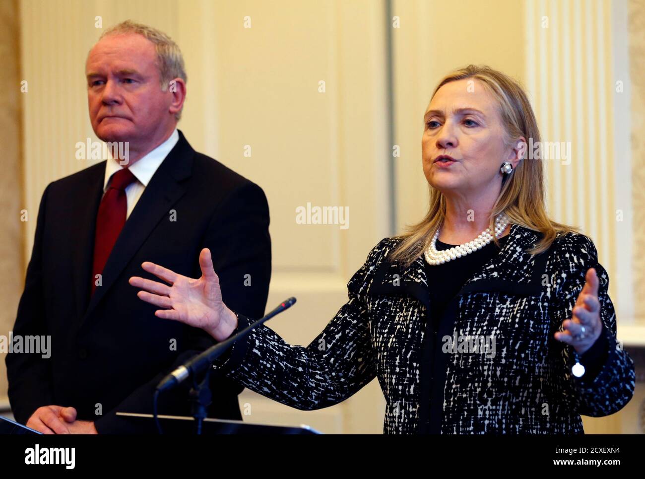 U.S. Secretary of State Hillary Clinton speaks during a news conference as Northern Ireland's Deputy First Minister Martin McGuinness listens at Stormont Castle in Belfast December 7, 2012. Clinton travelled to Northern Ireland on Friday to lend her support to the British province's fragile peace, the frailty of which was underlined by overnight rioting on the eve of her visit and the seizure of a bomb. REUTERS/Kevin Lamarque (NORTHERN IRELAND - Tags: POLITICS) Stock Photo