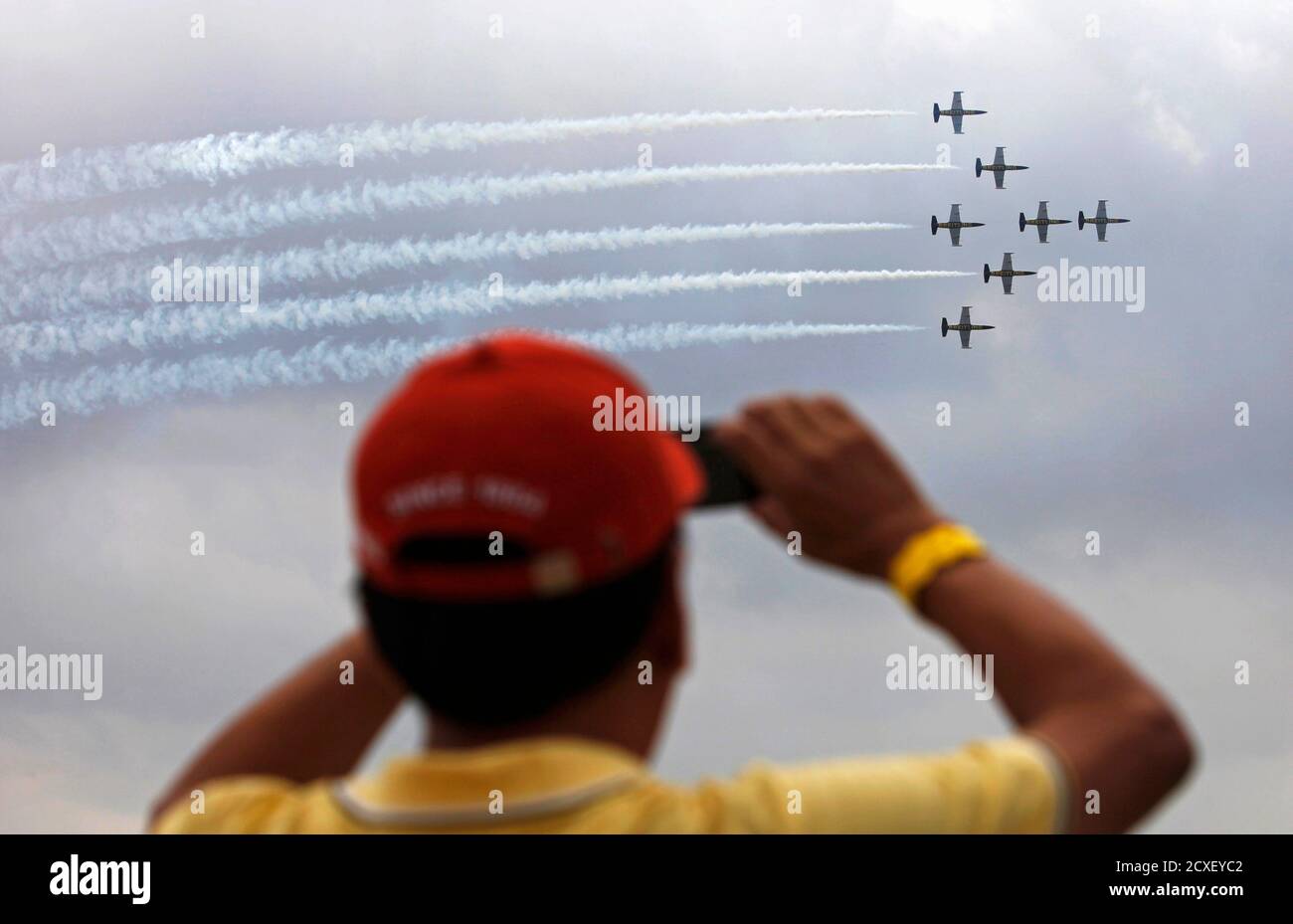 A spectator take pictures of the Breitling Jet Team's Aero L-39 Albatros jets during an aerobatics display over Singapore's Sentosa island March 9, 2013. The jet team is performing this weekend as part of their first Southeast Asia Tour. REUTERS/Edgar Su (SINGAPORE - Tags: TRANSPORT SOCIETY) Stock Photo