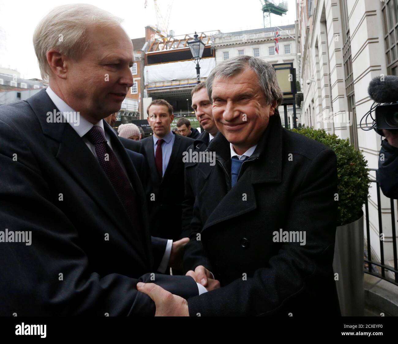 British Petroleum CEO Bob Dudley (L) and Rosneft CEO Igor Sechin shake hands outside the BP headquarters in central London March 21, 2013. Russian state oil company Rosneft closed its deal to buy TNK-BP from UK-based BP and four tycoons on Thursday, releasing $40 billion cash to the sellers and becoming a bigger oil producer than Exxon Mobil. The $55 billion deal, which also gives BP a near 20 percent stake in Rosneft, was announced last year after months of on-off negotiations. It is the biggest in Russia's corporate history.. REUTERS/Olivia Harris (BRITAIN - Tags: BUSINESS POLITICS ENERGY) Stock Photo