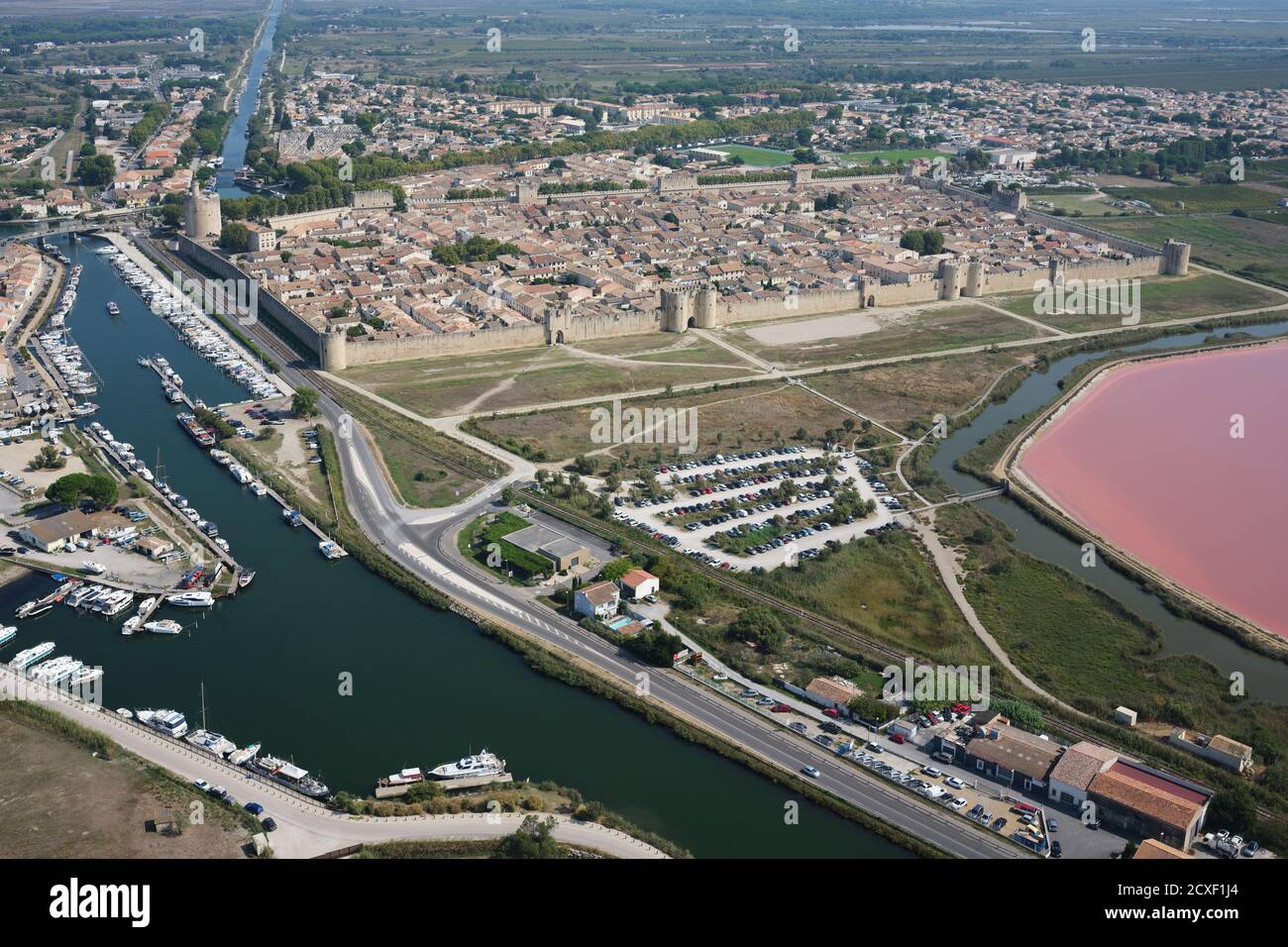 AERIAL VIEW. The medieval walled-town of Aigues-Mortes with the Rhône to Sète Canal on the town's western side. Gard, Occitanie, France. Stock Photo