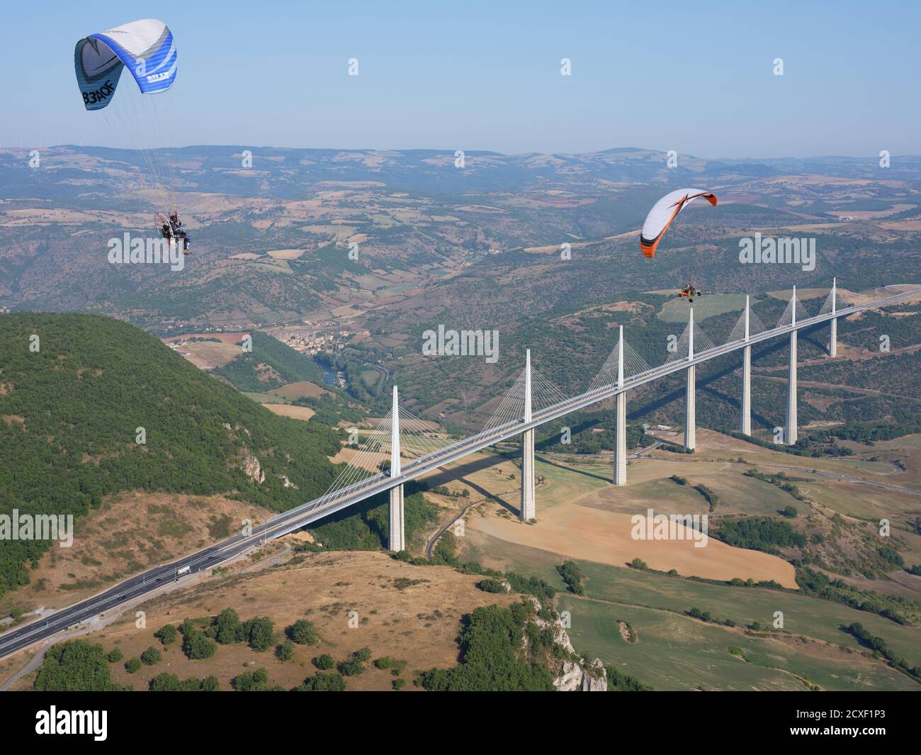 AIR-TO-AIR VIEW. Paramotors flying in the vicinity of the Millau Viaduct, the world's tallest bridge as of 2020. Millau, Tarn Valley, Aveyron, France Stock Photo