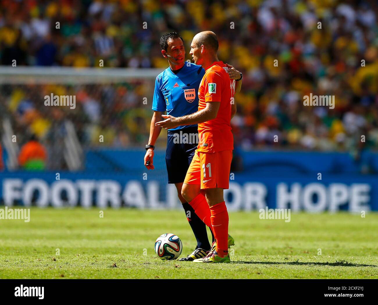 Arjen Robben (R) of the Netherlands speaks to referee Pedro Proenca of  Portugal as they take a water break during the 2014 World Cup round of 16  game between Mexico and the