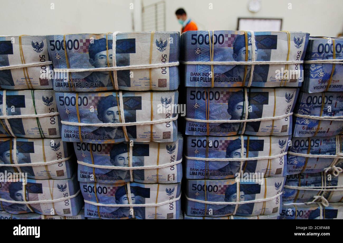 A bank employee sorts rupiah banknotes at the Bank National ...