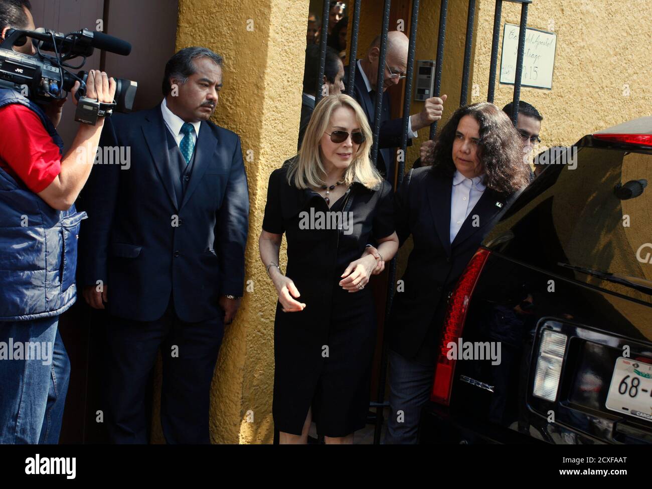 Silvia Lemus, wife of Mexican novelist Carlos Fuentes, is helped by Consuelo Saizar (R), director of the National Council for Culture and Arts as they leave her home towards to a tribute to the deceased writer in Mexico City May 16, 2012. Fuentes, one of Latin America's best-known authors and a sharp critic of governments in Mexico and the United States, died on Tuesday after a literary career spanning more than five decades. He was 83. REUTERS/Tomas Bravo (MEXICO - Tags: SOCIETY OBITUARY POLITICS ENTERTAINMENT) Stock Photo