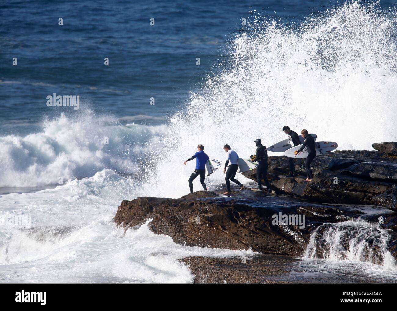 Competitors In The Inaugural Red Bull Cape Fear Invitational Surfing Tournament Step Across The Rocky Shoreline
