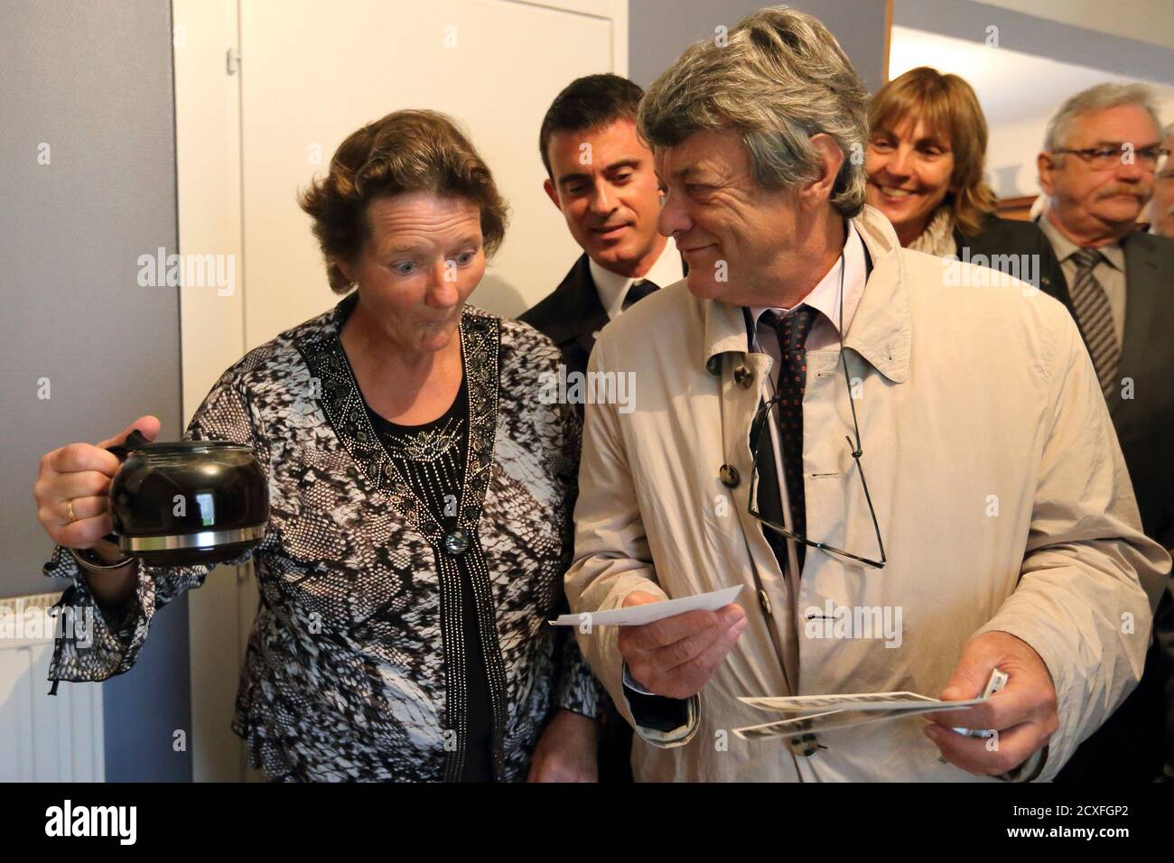 Catherine Marin, a local resident, prepares a coffee to French Prime  Minister Manuel Valls (C) and Jean Louis Borloo (R), former head of the  Union Democratic Independant (UDI) political party, as they