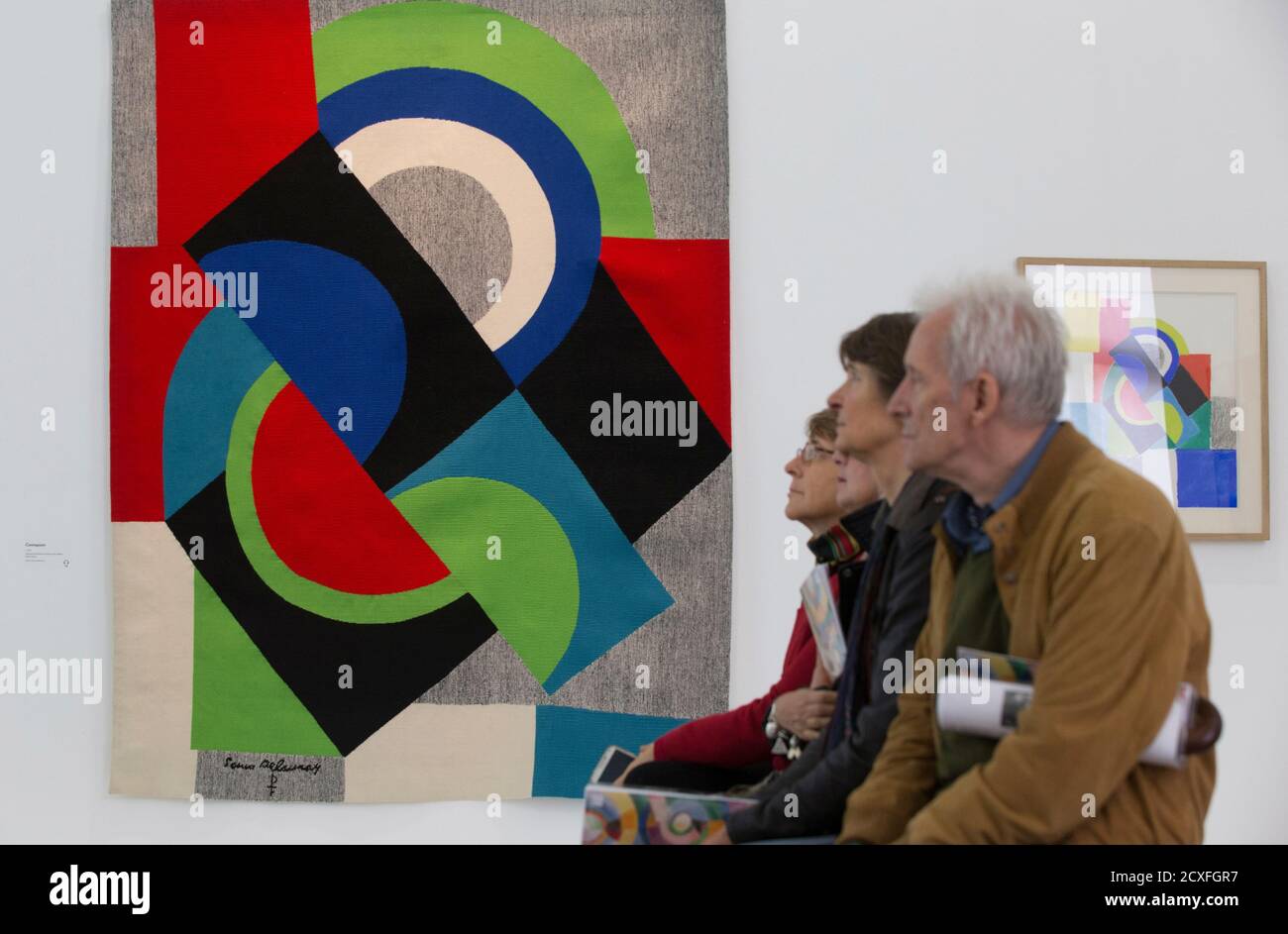 Visitors sit near paintings 'Contrepoints (1970)' (L) and 'Rythme Couleur (1967)' by artist Sonia Delaunay (1885-1979) during the press visit of the exhibition 'Sonia Delaunay, The Colours of Abstraction' at the Musee d?Art Moderne (Modern Art Museum) in Paris October 16, 2014. The exhibition, which traces the artist's evolution since the beginning of the 20th century to the late 1970s with over 400 works, will run from October 17, 2014 to February 22, 2015.    REUTERS/Philippe Wojazer  (FRANCE - Tags: SOCIETY) Stock Photo